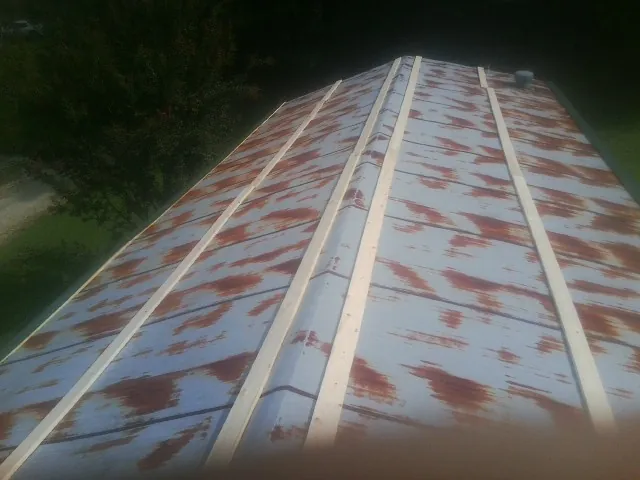 Rusted metal roof panels with new wood purlins before replacement — Storm Damage Roof Repair in Willoughby by Roofing Brothers