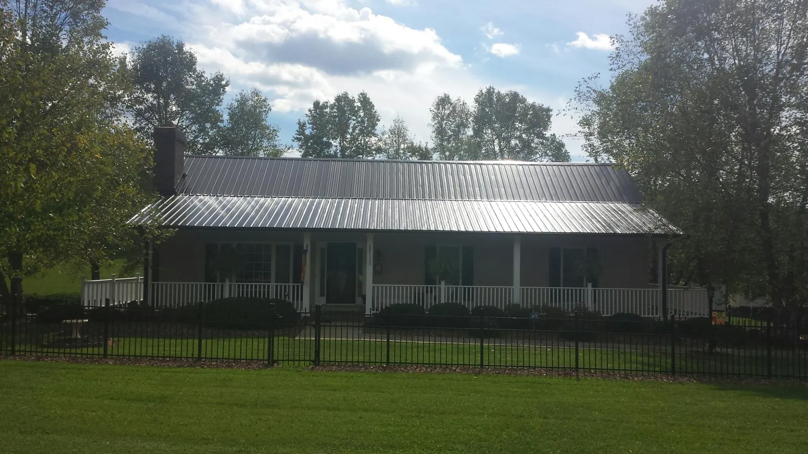 Gray metal roof on a brick ranch with a full width front porch — Gutter Guard Installation work by our crew in Willoughby