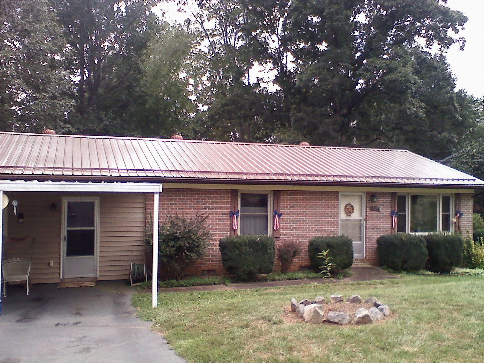 Bronze metal roof and carport on a brick ranch home — Roof Repair work by our crew in Willoughby